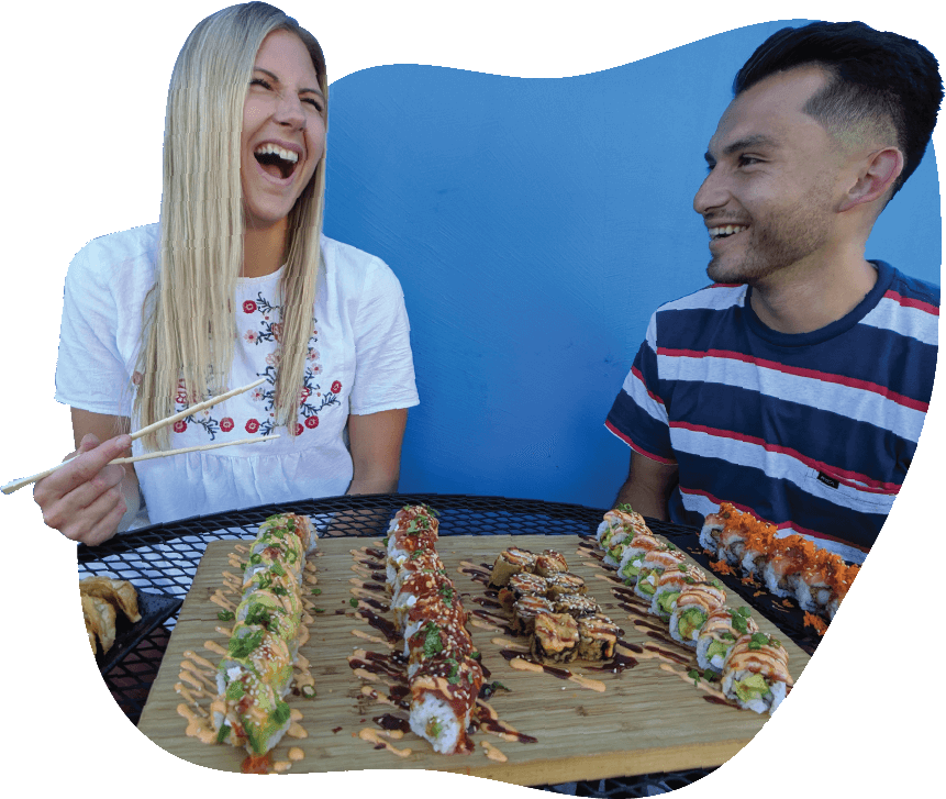 A young female and young man enjoying sushi
