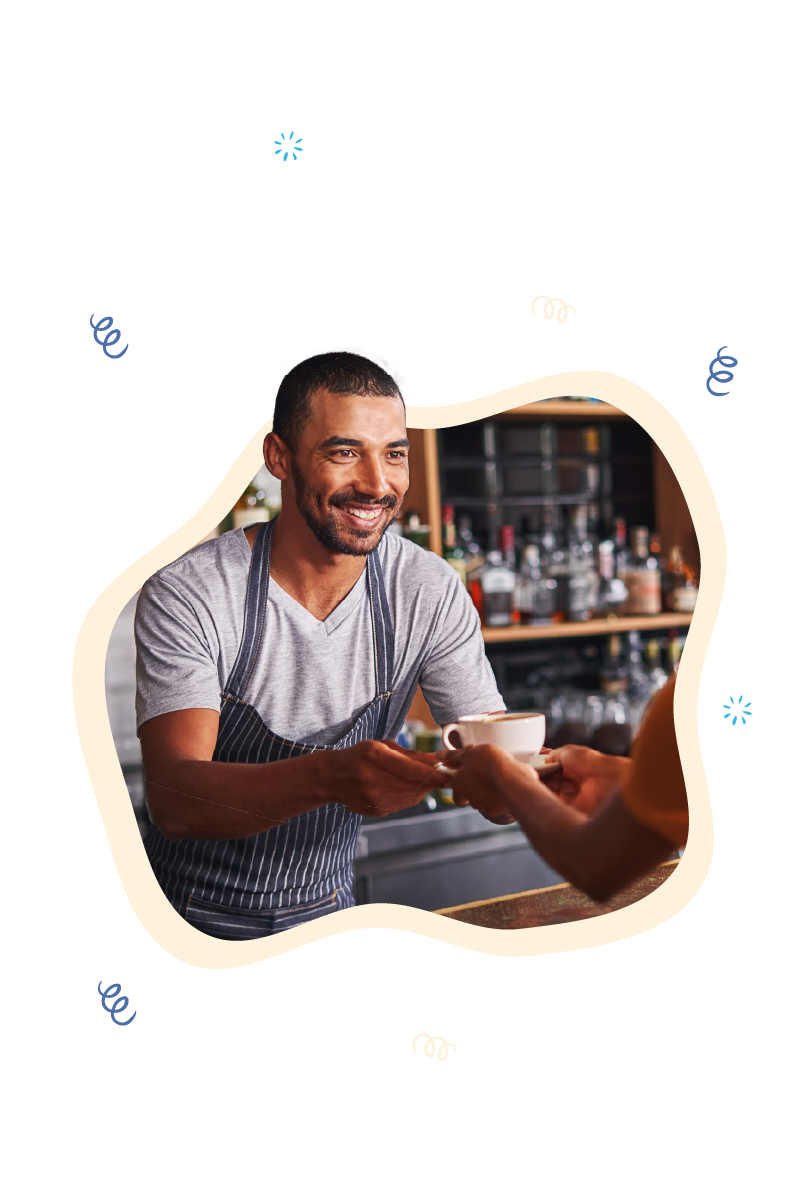 Smiling barista in a coffee shop handing over a freshly made cup to a customer, showcasing the efficient operation of a coffee shop POS system. The system is designed for quick service and ease of use, vital for the fast-paced environment of a bustling coffee shop.